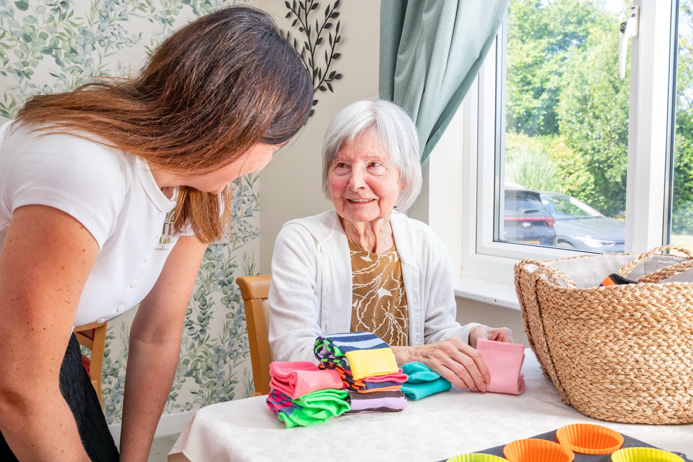 A staff member and resident sorting colourful fabrics