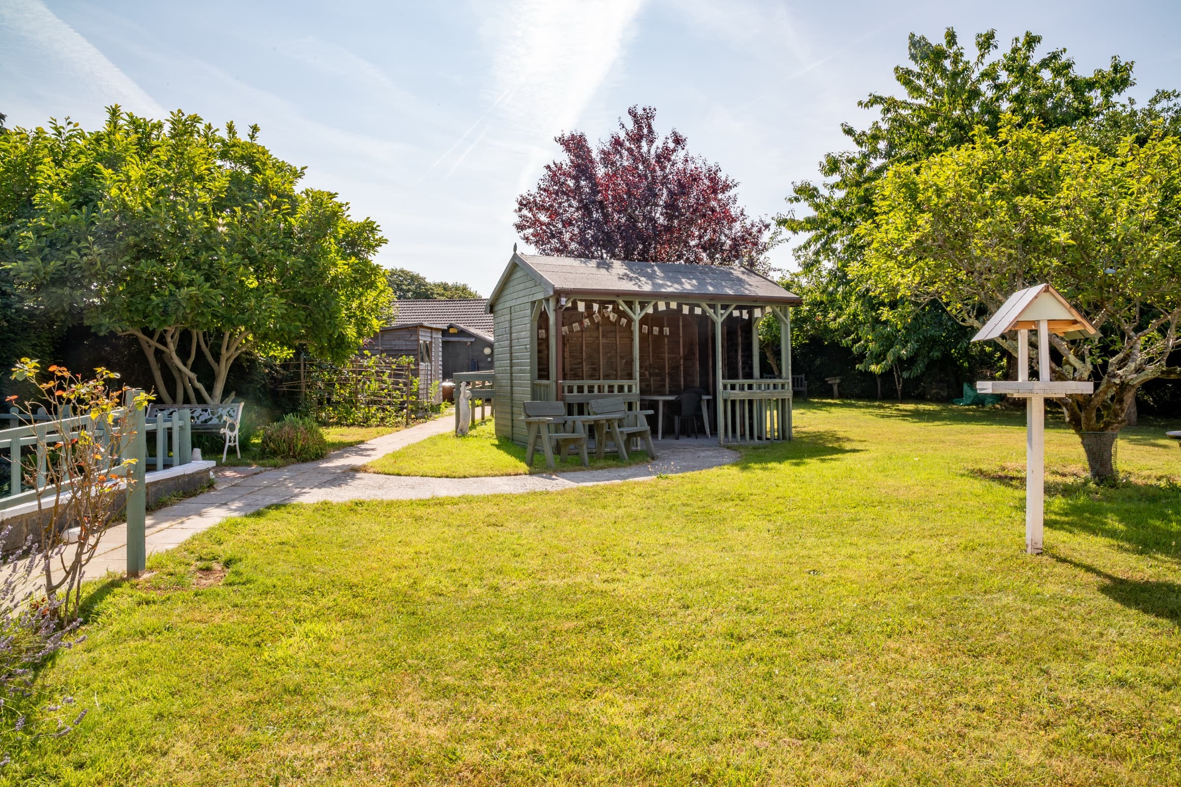 Covered garden shelter with seating on the lawn