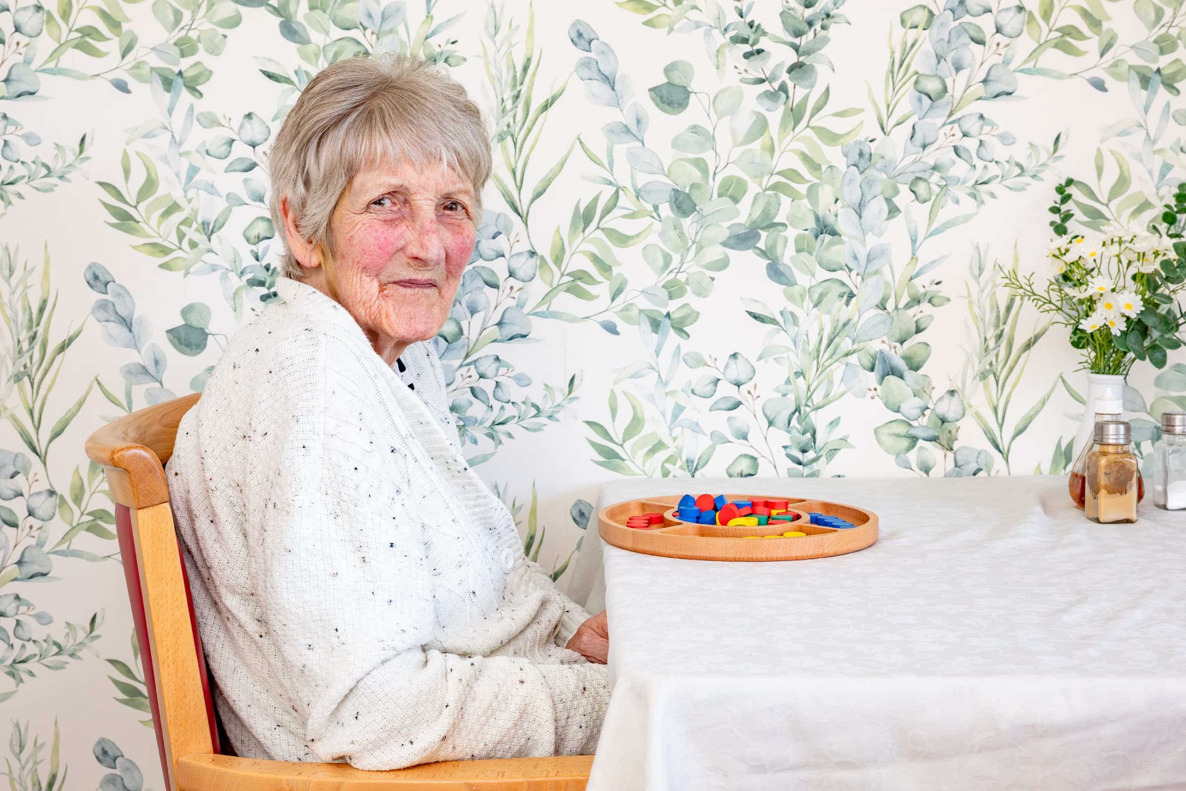 A resident at a table with a wooden game