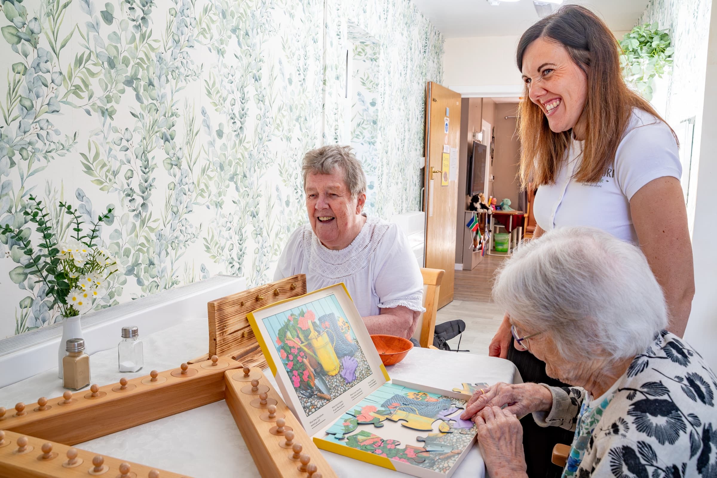 Residents and a staff member doing a jigsaw together
