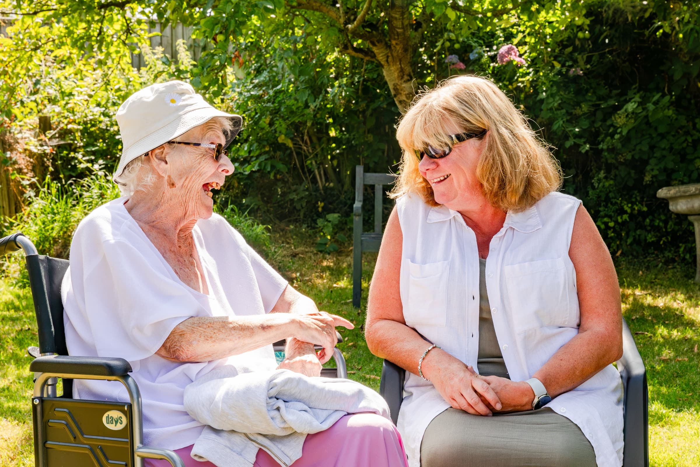 A resident and a member of staff chatting in the garden