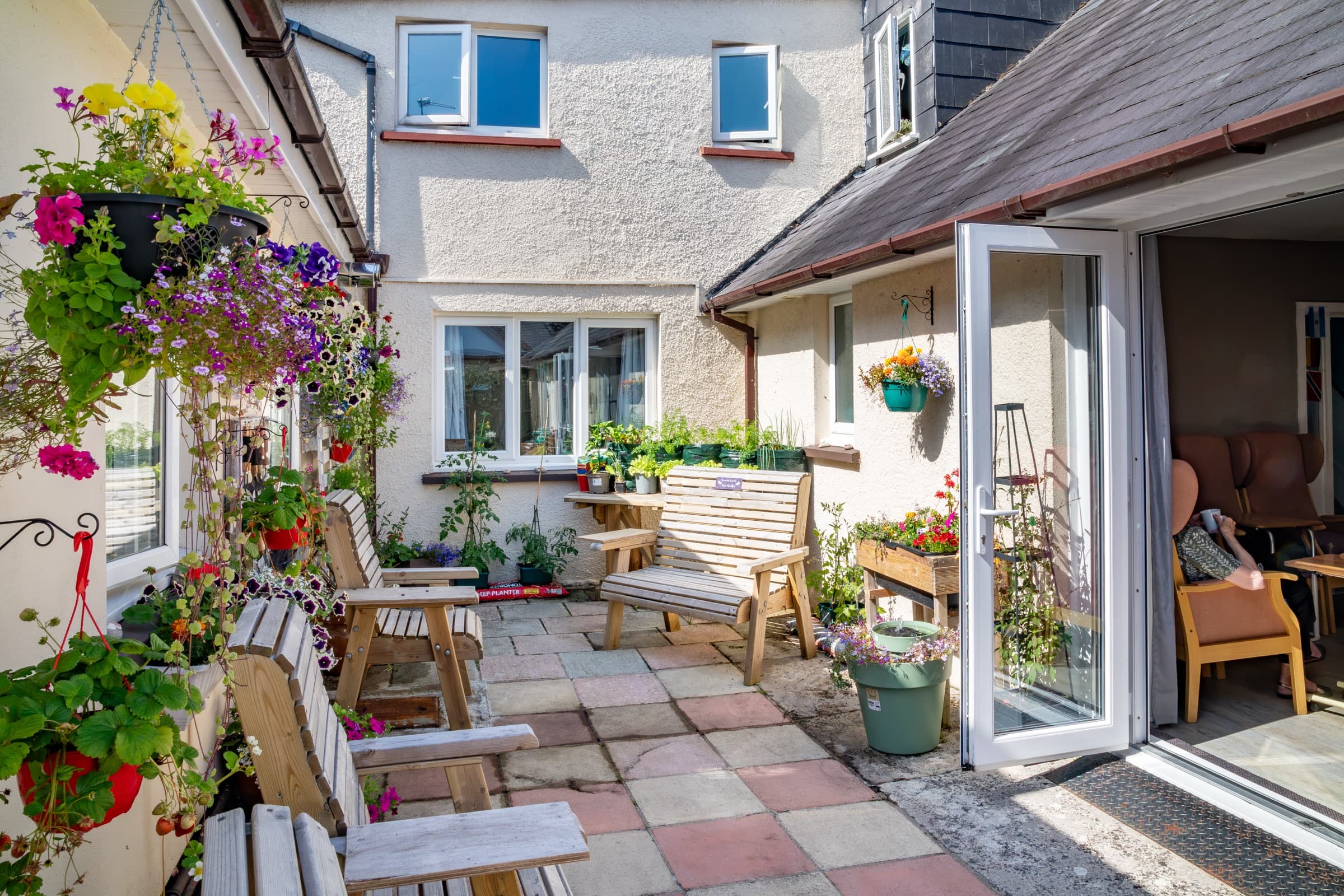Sunny courtyard with hanging baskets and garden seating