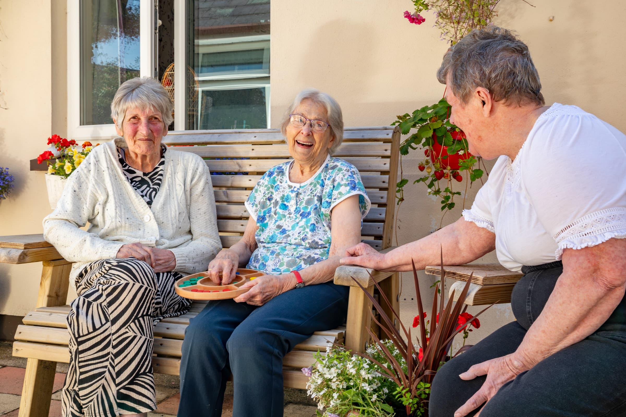Three residents chatting on a bench in the courtyard